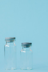 Vial of medicine on blue background with copy space. Antibiotic or vaccine medication. Healthcare and pharmacy innovations