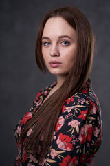 Portrait of a female in a colored dress on gray background