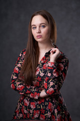 Portrait of a female in a colored dress on gray background