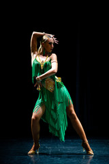 young beautiful female dancer posing on black background