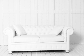 White room with sofa and empty background wall with LED garland
