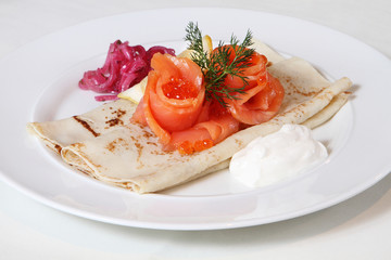 homemade pancakes with pieces of pickled red fish on a plate