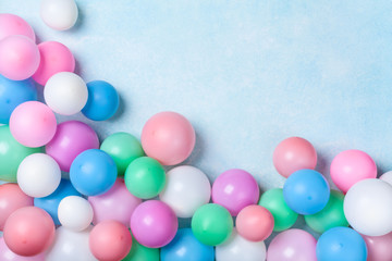 Fototapeta na wymiar Heap of colorful balloons on blue pastel table top view. Birthday or party background. Flat lay style. Copy space for text.