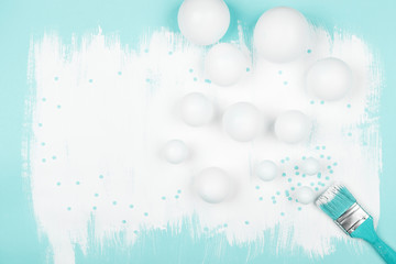 Creative mint color background with white balloons, confetti and brush with paint. Top view and flat lay. Birthday or party concept.