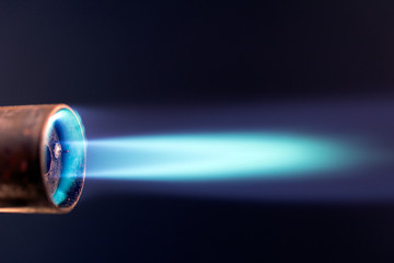 gas torch blue flame. Industrial gas burner, close up dark background