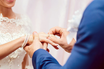 the groom wears a wedding ring on the bride's close