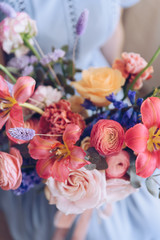 Young woman in a light blue dress holding a bouquet of flowers. Romantic concept.