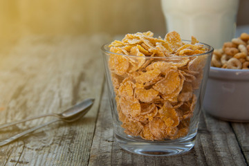 Bowl with cornflakes on grey wooden background. Healthy cereal breakfast for kids. Copy space.