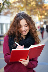 young school girl writing on an notepad
