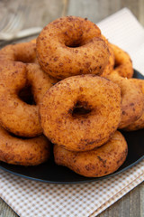 Homemade donuts. round, circle delicious donuts in black plate, wooden background. Isolated dessert or breakfast.