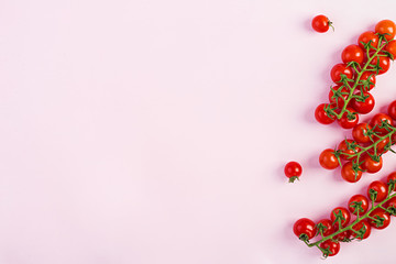 Isolated fresh red cherry tomatoes on pink background. Top view. Flat lay