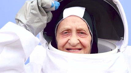 Old senior woman playing with astronaut costume