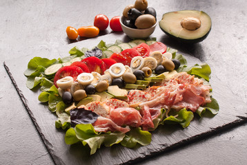 Cobb salad. Main-dish American garden salad typically made with chopped salad greens , tomato, crisp bacon, grilled chicken breast, hard-boiled eggs, avocado, chives, Roquefort cheese. Top view.