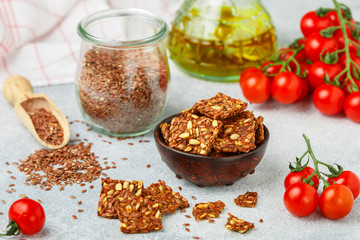 Homemade vegetarian (vegan) cracker flax seed and sunflower with tomato. Healthy gourmet snack. Proper nutrition, diet, superfood. Selective focus