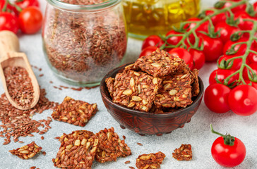 Homemade vegetarian (vegan) cracker flax seed and sunflower with tomato. Healthy gourmet snack. Proper nutrition, diet, superfood. Selective focus