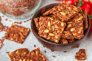Homemade vegetarian (vegan) cracker flax seed and sunflower with tomato. Healthy gourmet snack. Proper nutrition, diet, superfood. Selective focus