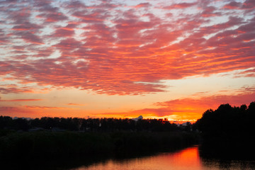 Colorful cloud scape of red altocumulus clouds at sunset near Gouda, Netherlands.