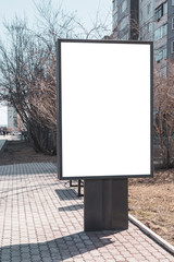 Fototapeta premium Vertical small billboard in the city on the sidewalk. Mock up for your advertising or announcements