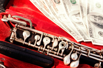 Musical wind instrument oboe in original red case and us dollars. Close-up. Concept money in art.