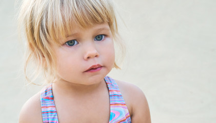 Portrait of little girl in swimsuit on sunny day outside. Concept of summer recreation, travel and...