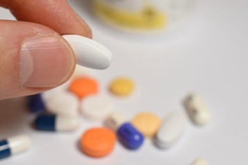 Various medical pills and capsules picked up with hand
