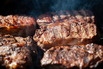 Beef steak cooking. Rib eye steak. Raw meat. Juicy marbled meat on BBQ grill. Medium rare meat roasting