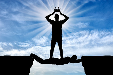 Selfish man puts his crown on his head, he is on the man in the form of a bridge over the abyss
