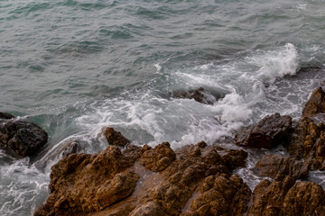 Fototapeta na wymiar The ocean waves hit the rocks on the rocky beach in the morning, Ocean waves hit the rocks at the beach.