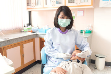 Dentist examining a boy patient's teeth in the dentist.