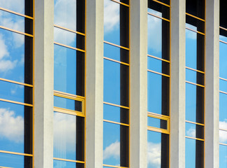 beautiful urban architecture background. window reflection of a clouds on a blue sky. perspective side view with five columns