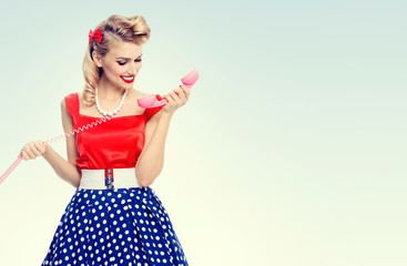 smiling woman with phone, dressed in pin-up style dress