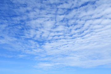 White clouds in bright blue sky as background