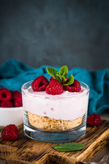 No baked cheesecake with raspberry in glass jar.