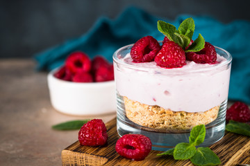 No baked cheesecake with raspberry in glass jar.