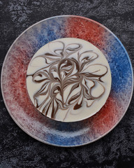 Delicious cake with milky glaze and chocolate decor. Top view. Delicacy. Black background.