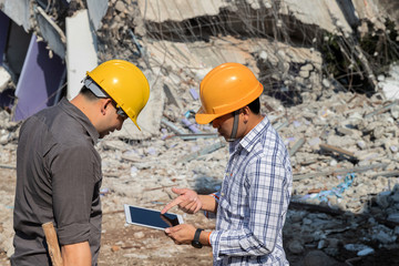 Demolition control supervisor and foreman discussing on demolish building.