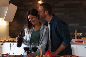young couple of lovers celebrating at home drinking wine
