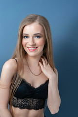 Young beautiful girl in black bra with hands on neck.
