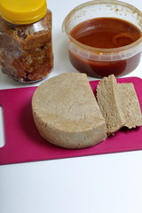 Sliced halva from honey, peanuts and sunflower seeds. Near honey in different containers. Ingredients and tools for making halva.