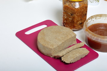 Sliced halva from honey, peanuts and sunflower seeds. Near honey in different containers. Ingredients and tools for making halva.