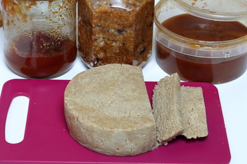 Sliced halva from honey, peanuts and sunflower seeds. Near honey in different containers. Ingredients and tools for making halva.