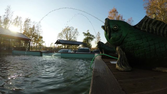 The fountain with two sculptures of fish in the suburban recreational facility.