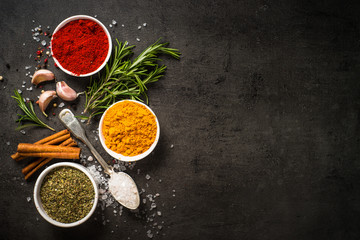Set of various spices on black background.