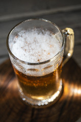 Mug of fresh light beer on wooden background