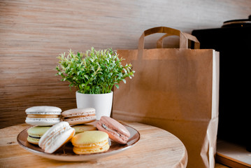 Kitchen plate with colorful macaroon. Wooden table