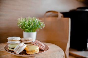 Kitchen plate with colorful macaroon. Wooden table