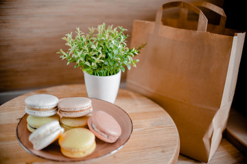 Kitchen plate with colorful macaroon. Wooden table