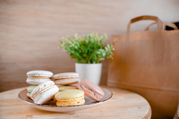 Kitchen plate with colorful macaroon. Wooden table