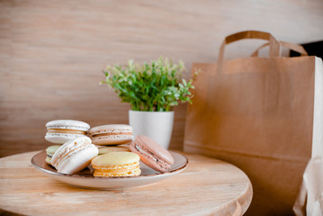 Kitchen plate with colorful macaroon. Wooden table