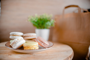 Kitchen plate with colorful macaroon. Wooden table